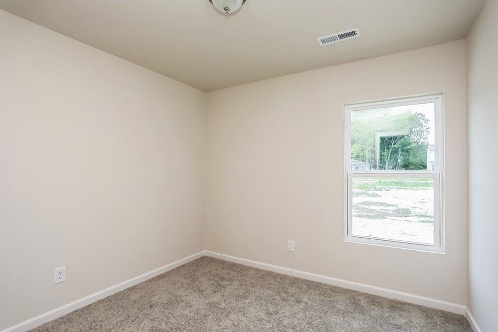 an empty room with a window and carpet