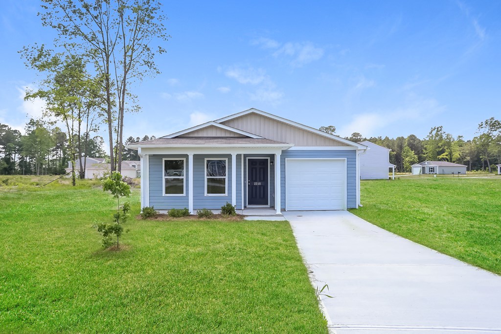 a small blue house with a sidewalk in front of it