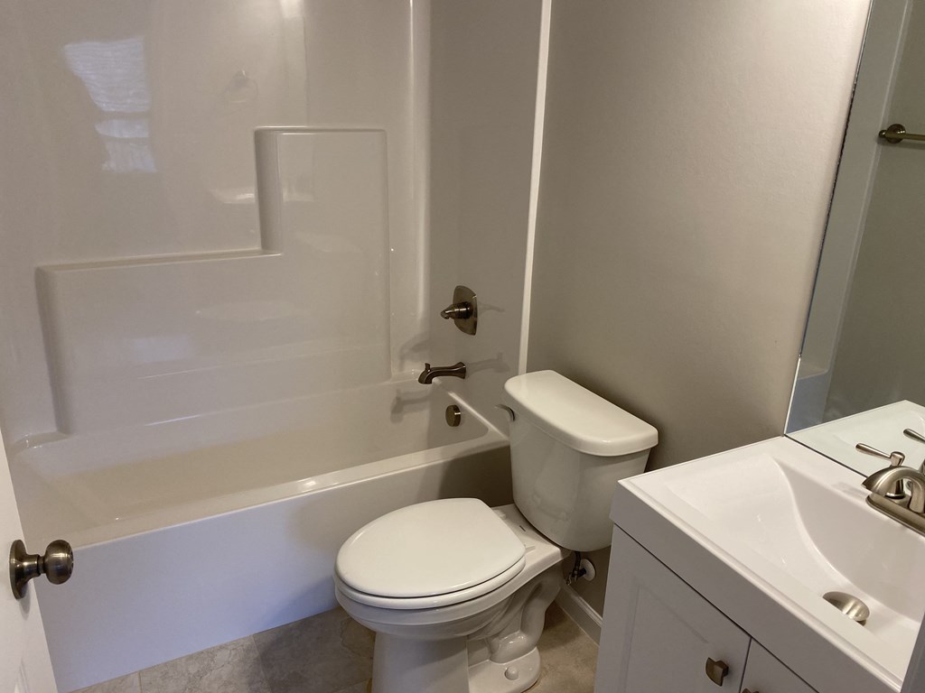 a bathroom with a toilet and a tub and a sink