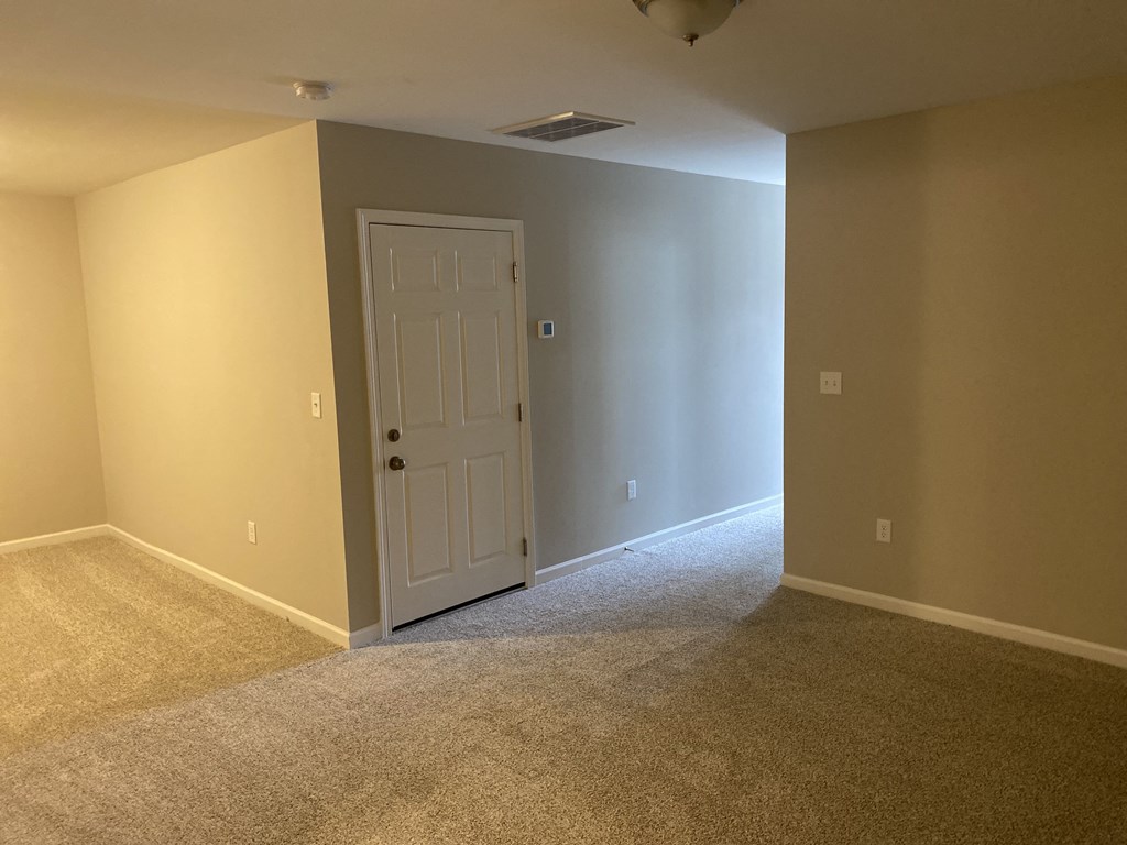 a empty room with a door and a carpeted floor