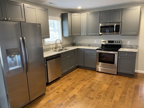 a kitchen with stainless steel appliances and gray cabinets