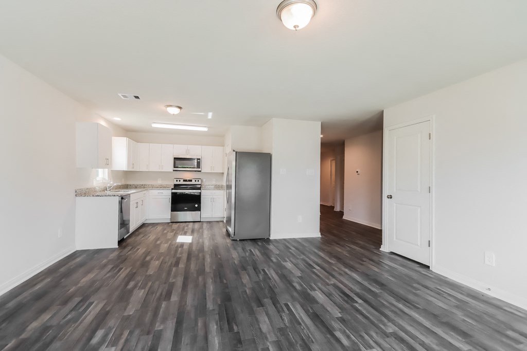an empty living room and kitchen in a new home