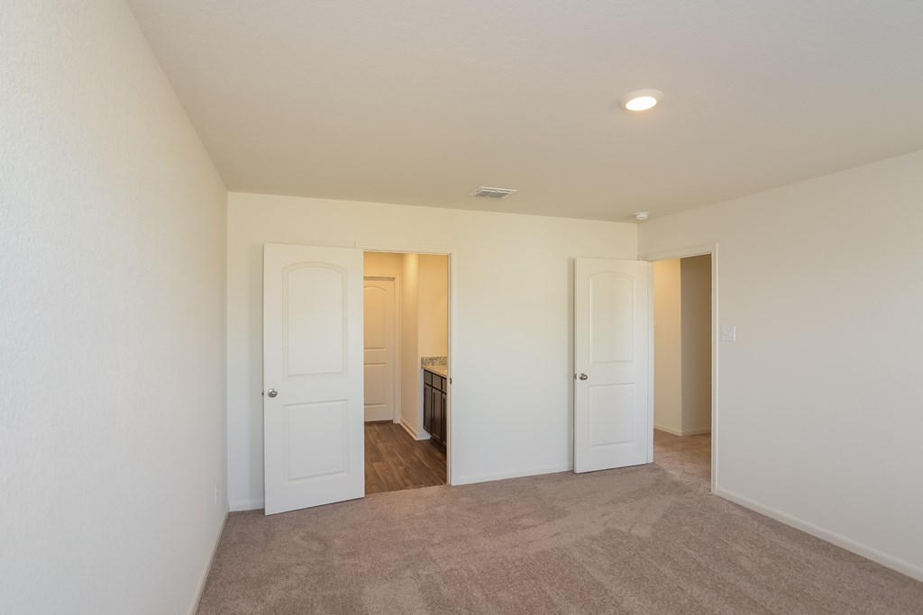 a living room with white doors and a carpeted floor