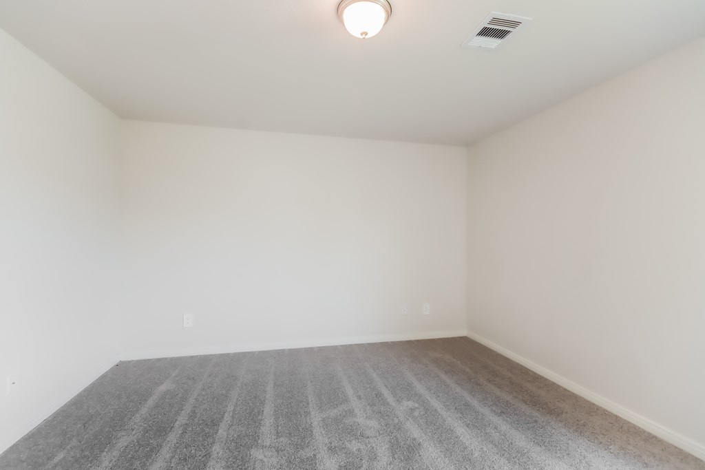 an empty room with a carpeted floor and white walls