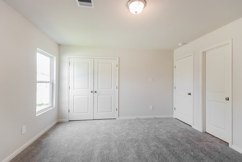 an empty living room with white doors and carpet