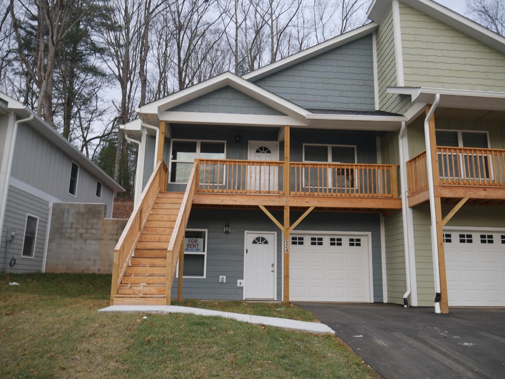 the front of a house with a deck and a garage