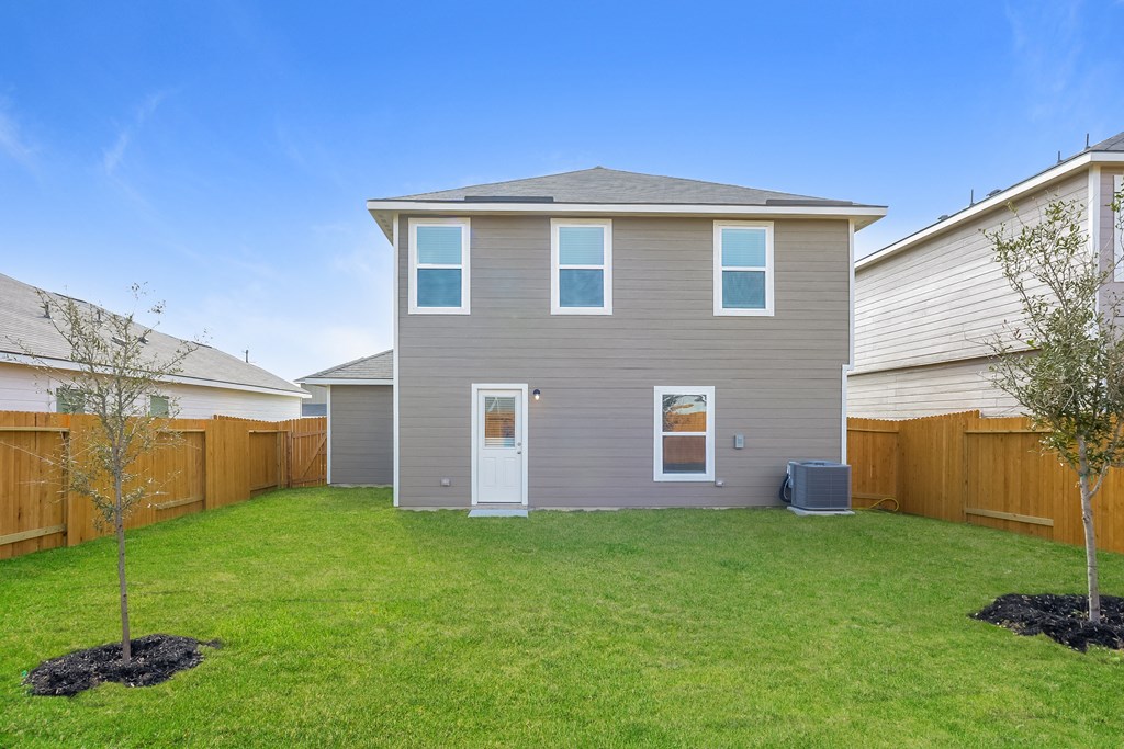 the backyard of a house with a lawn and a fence