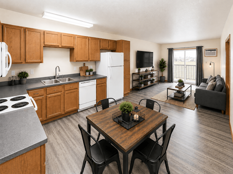 A kitchen with a dining table and chairs in the foreground.