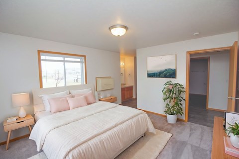 A bedroom with a large bed and a window.