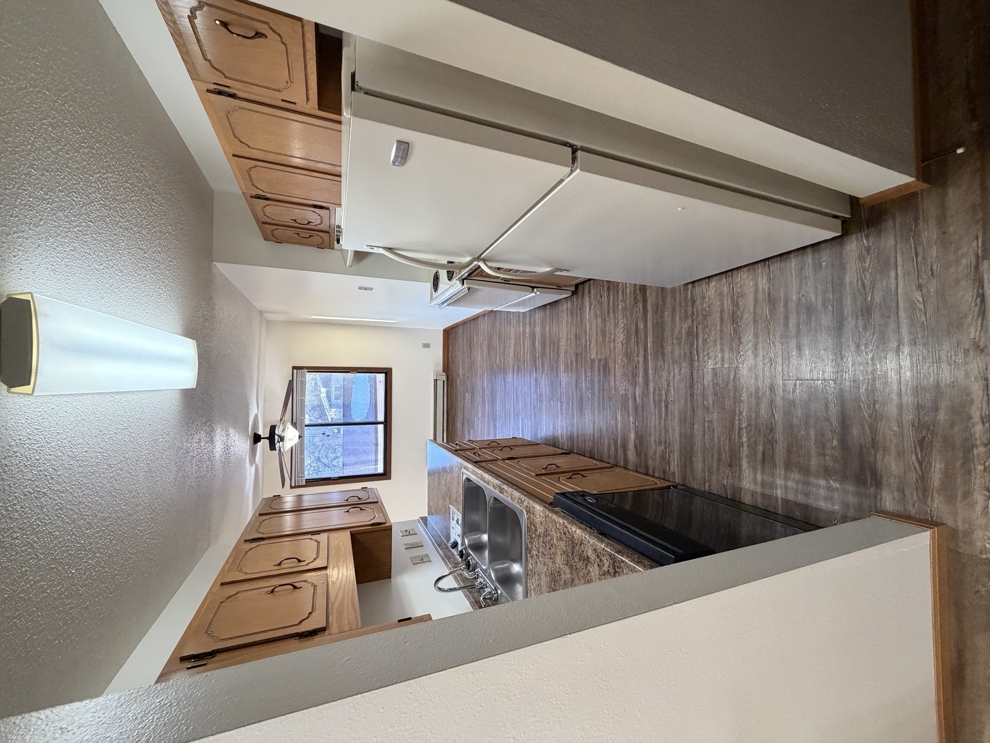 A kitchen with a stove top oven and a window.