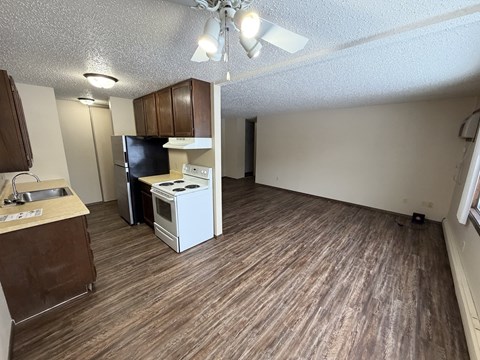 A kitchen with a white stove top oven and a black refrigerator.
