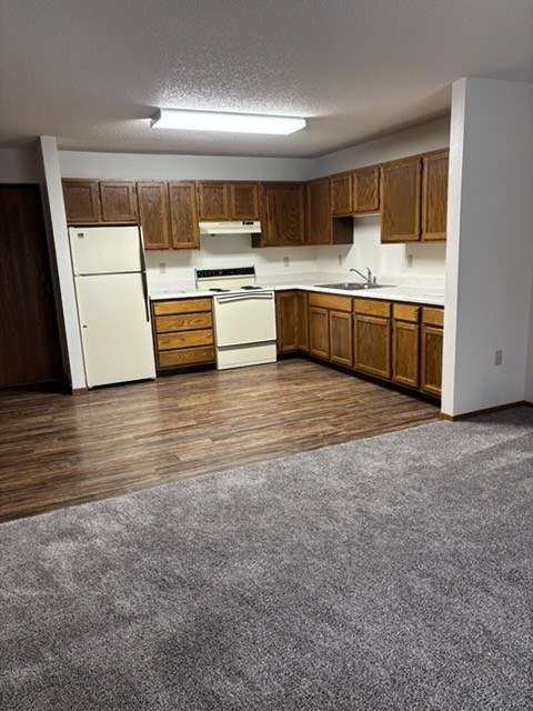 A kitchen with wooden cabinets and a white fridge.