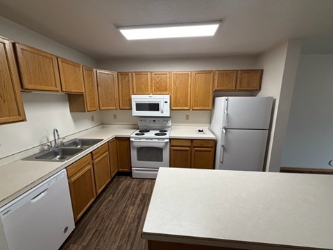 A kitchen with wooden cabinets and white appliances.