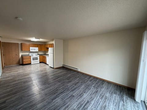 A kitchen with wooden cabinets and a white fridge is visible.