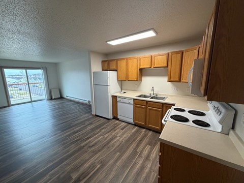 A kitchen with wooden cabinets and a white stove top oven.