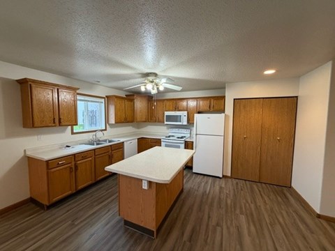 A kitchen with wooden cabinets and a white countertop.