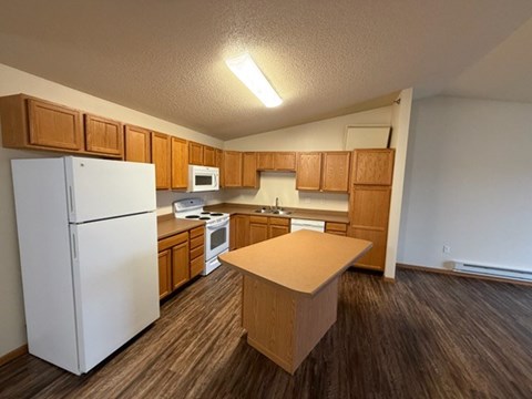 A kitchen with wooden cabinets and a white refrigerator.
