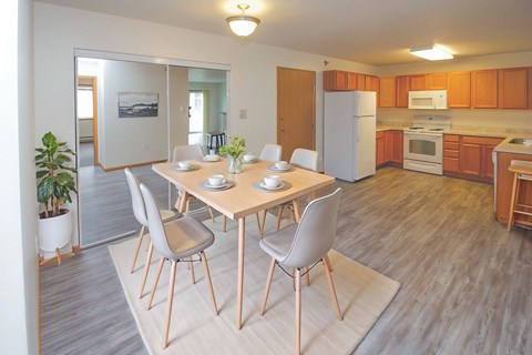 A kitchen with a dining table and chairs.