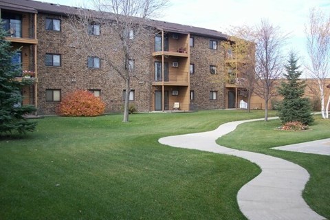 Apartment complex with a walkway in the grassy area.