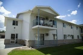 A white two-story apartment building with balconies on the second floor.
