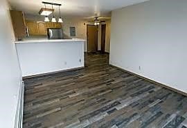 A kitchen area with a white counter and a wood floor.