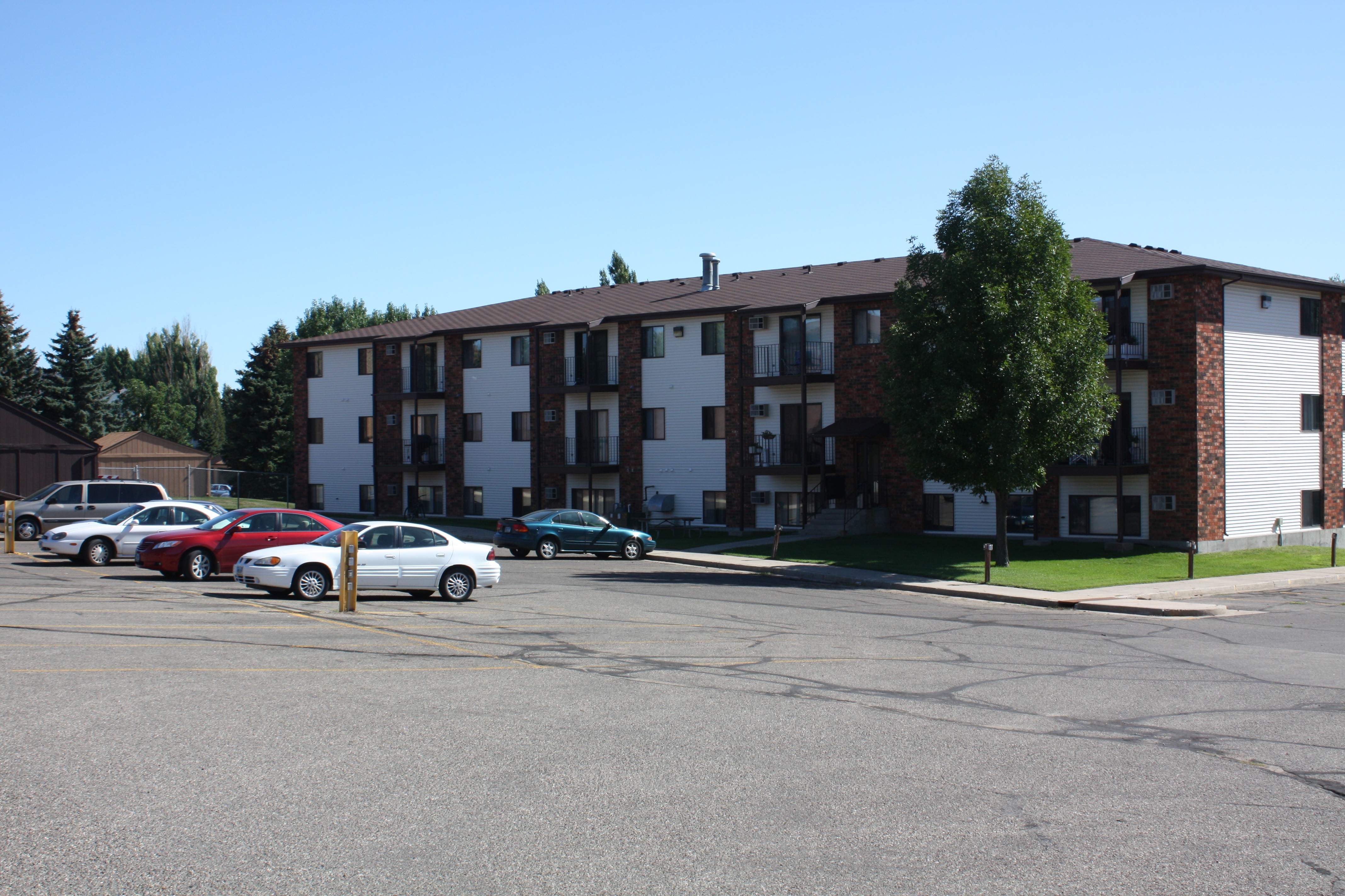 A parking lot with cars and a building in the background.