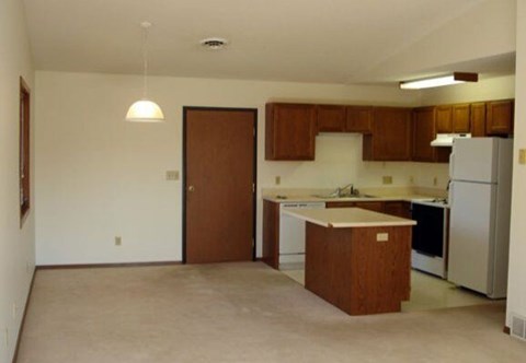 A kitchen with white appliances and brown cabinets.