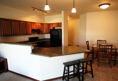 A kitchen with a bar area and a dining table.