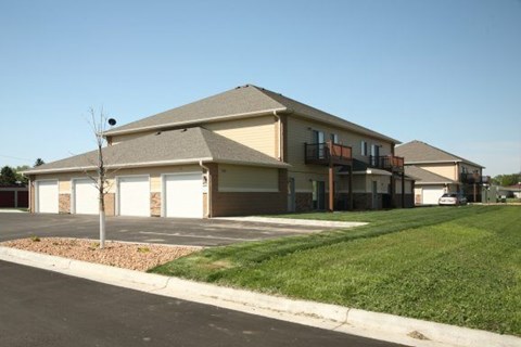 A building with a brown roof and white garage doors.