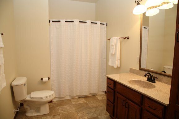 A bathroom with a toilet, sink, and shower curtain.