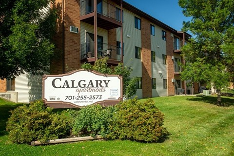 A Calgary apartments sign in front of a building.