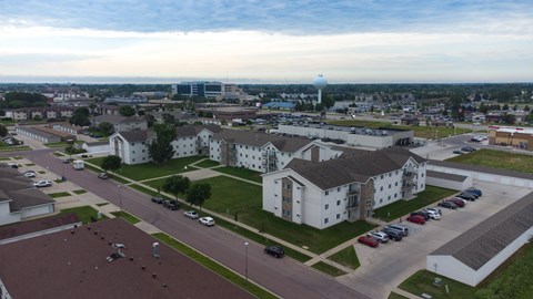 A parking lot with cars and a white building in the background.