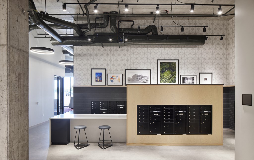 a tasting room with a counter and stools in a room with exposed ducts