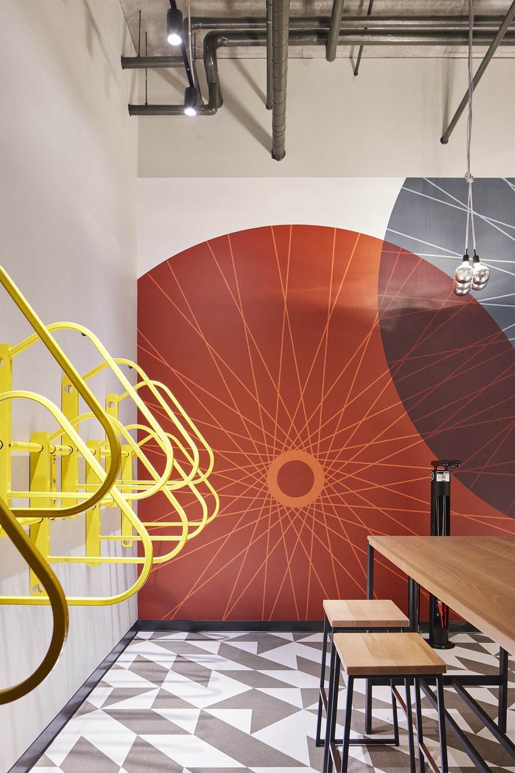 a mural of a spiral staircase in a restaurant with tables and stools