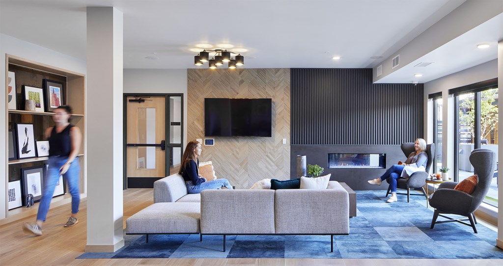 a living room with a couch and a fireplace and people in it