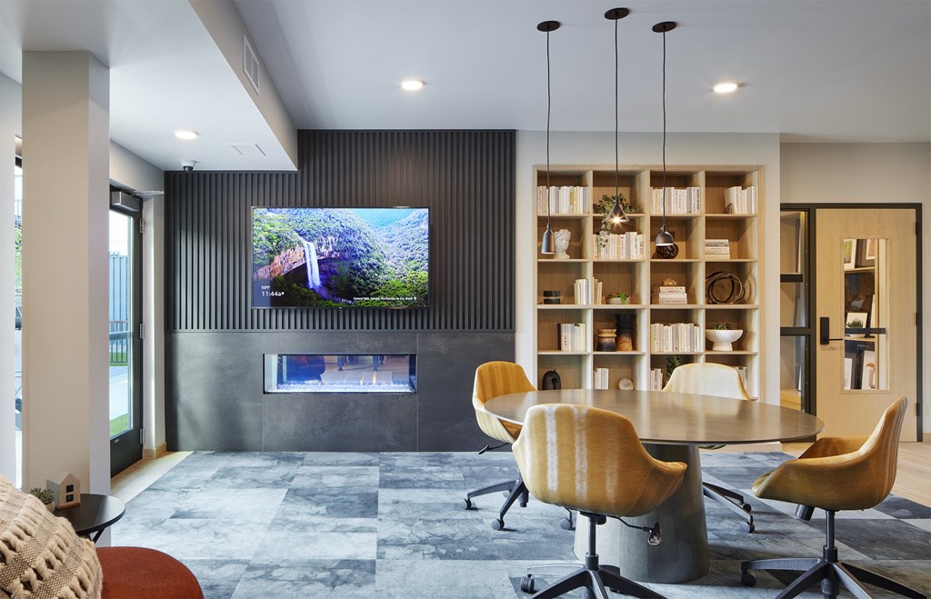 a living room with a tv on the wall and a table and chairs