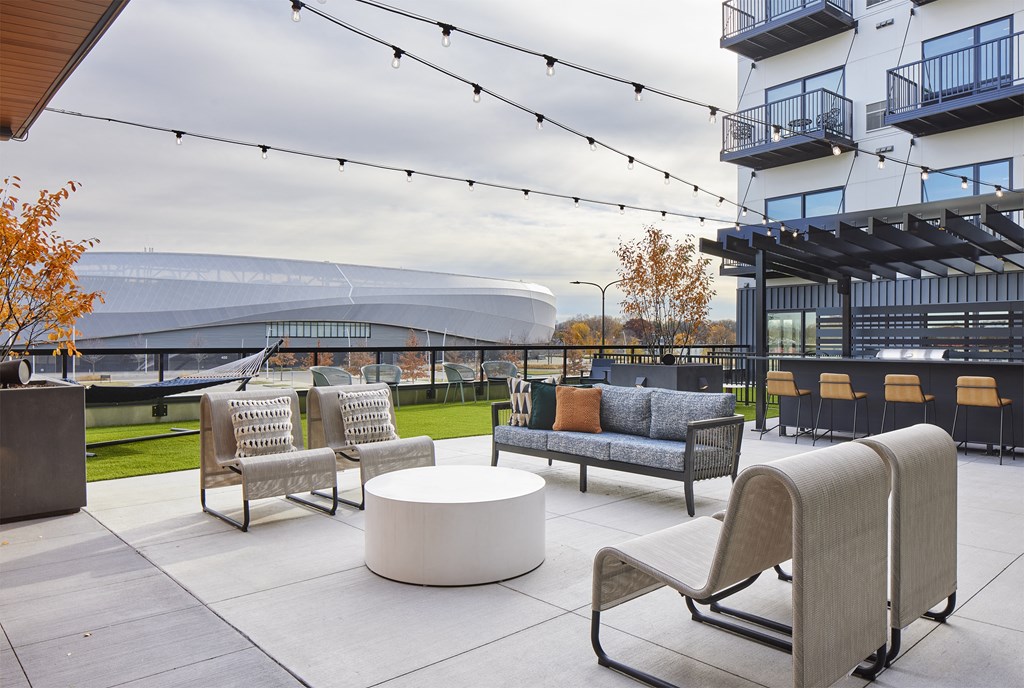 a patio with chairs and tables and a building in the background