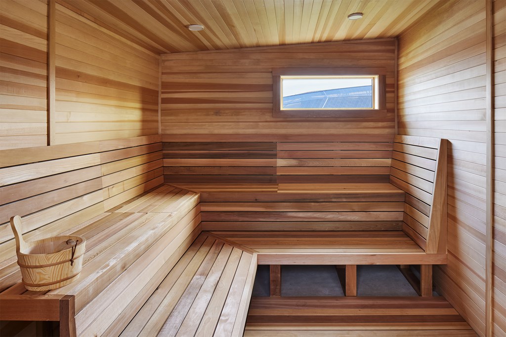 a wooden sauna with a bench and a window