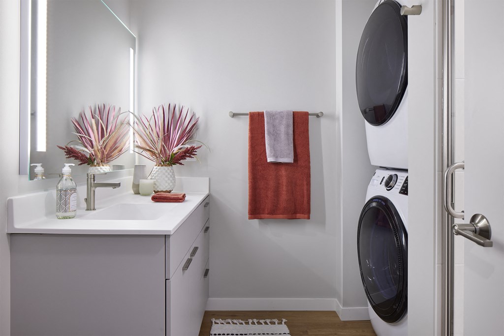 a small bathroom with a washer and dryer and a sink