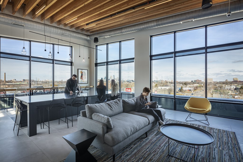 a man sitting on a couch in a living room with a view of the city