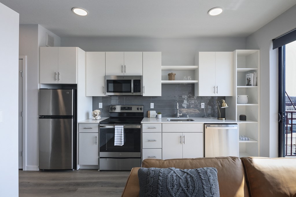 a kitchen with white cabinets and stainless steel appliances