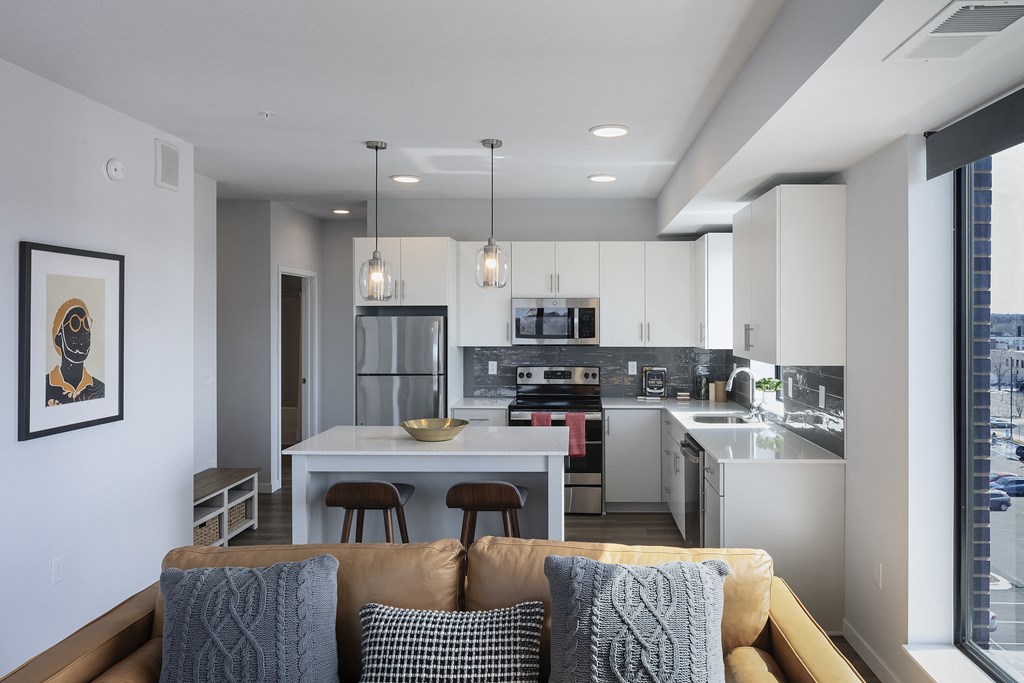 an open kitchen and living room with a couch and a table