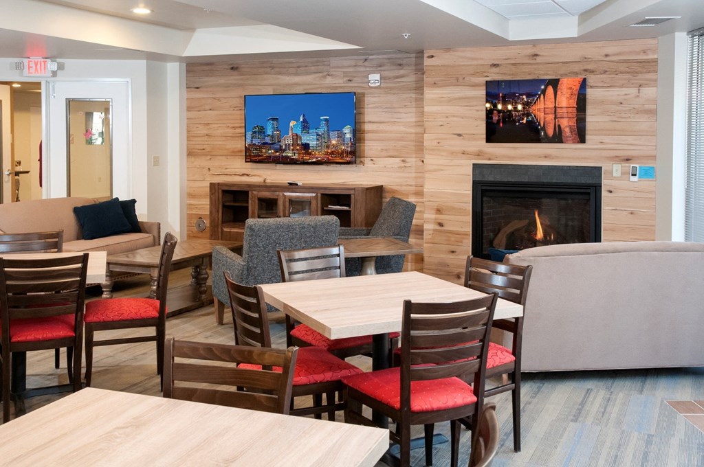a dining room with tables and chairs and a fireplace