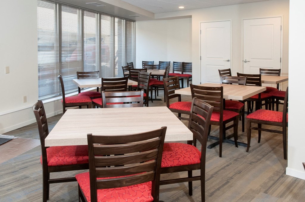 a dining room filled with tables and chairs and windows