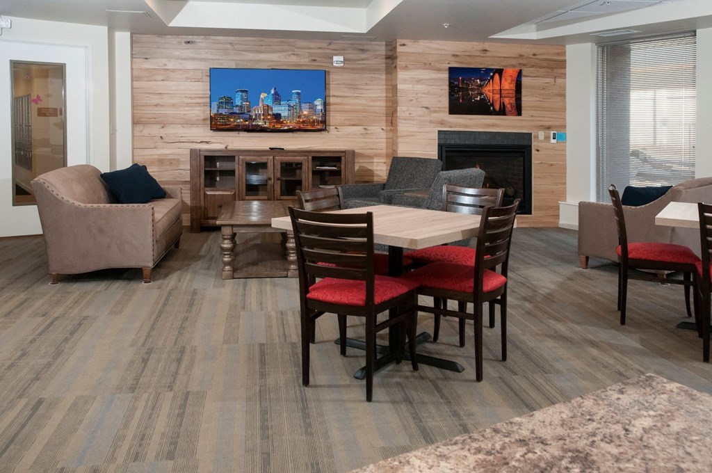 a living room with a table and chairs and a fireplace