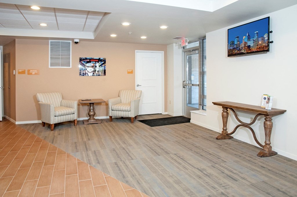 a waiting room with two chairs and a table and a television