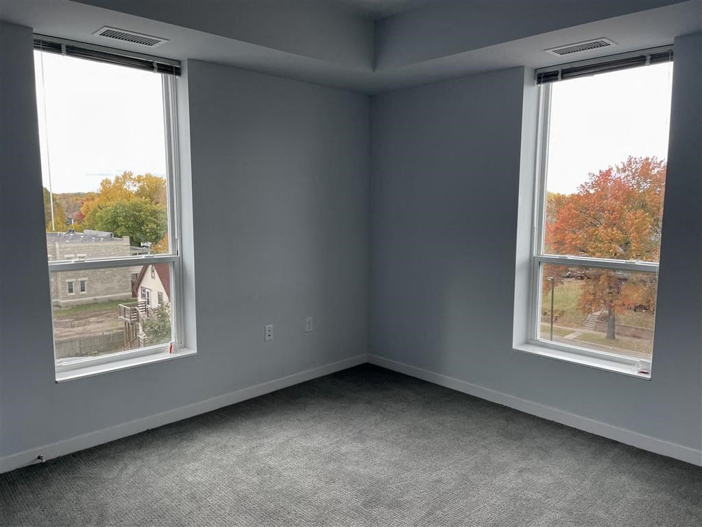 an empty room with two large windows