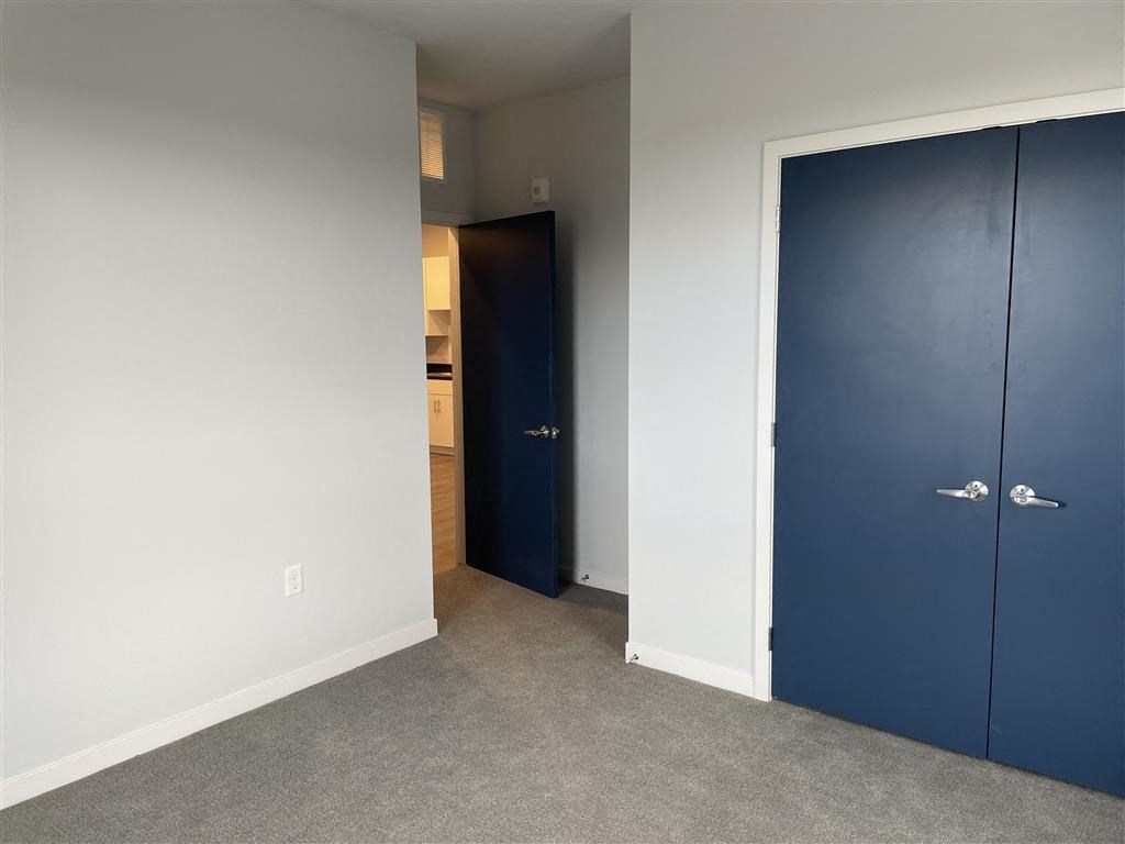 a bedroom with a blue door and a white wall