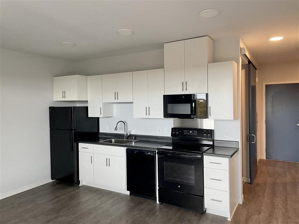 a kitchen with white cabinets and black appliances