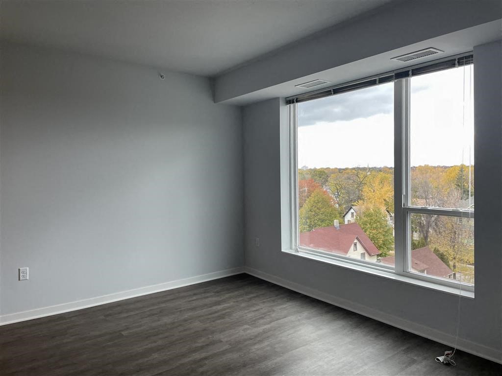 an empty room with a large window and a view of a house